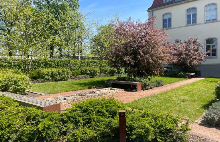 Parkplatz Roter und silberner Kompaktwagen parken nebeneinander auf einem Parkplatz.