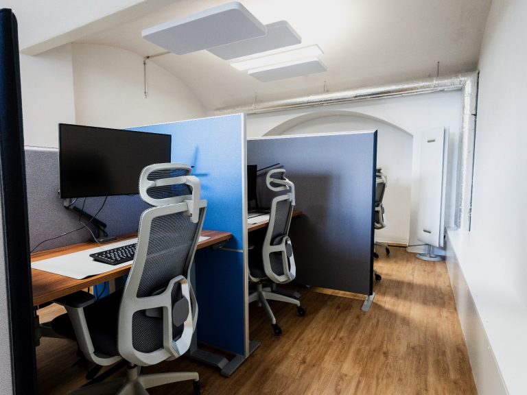 Moderne Büroumgebung mit Bildschirmarbeitsplätzen und ergonomischen Stühlen.