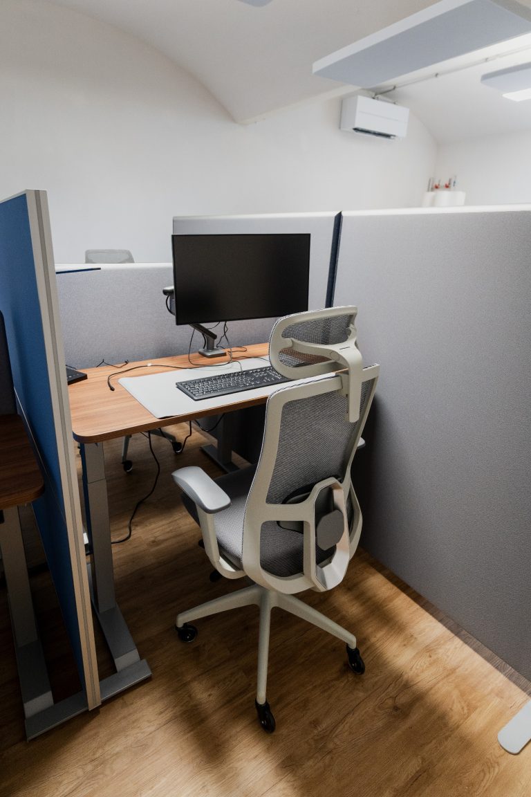 Ausgestattete Arbeitsplätze im Coworking Space nahe Dresden Büroarbeitsplatz mit Schreibtisch, Monitor und ergonomischem Stuhl in einem abgetrennten Bereich.