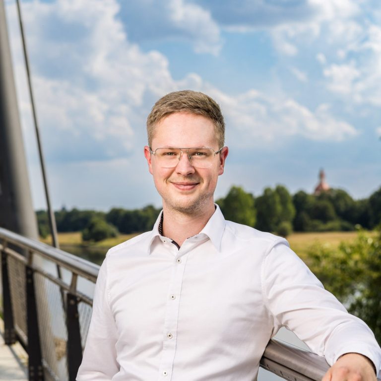 Freundlich lächelnder junger Mann. Der Inhaber von Hub & Spoke, Max Virkus.