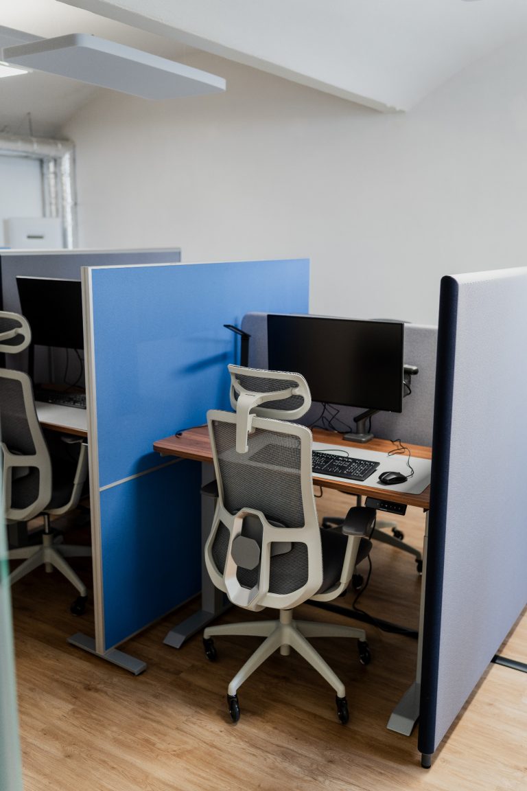 Ergonomische Arbeitsplätze Büro mit zwei Arbeitsplatzkabinen, jeweils mit einem Computer und ergonomischen Stühlen.