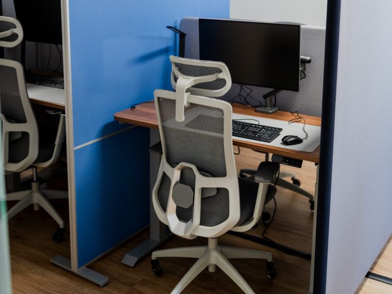 Büroarbeitsplatz mit modernen Stühlen und Computermonitoren in einem offenen Raum.